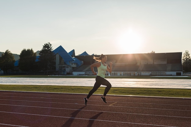 写真 陸上競技場でのレーストレーニング中に強い白人の若い女性ランナーに焦点を当てた