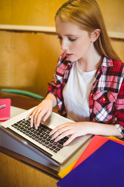 Photo focused student using laptop during class