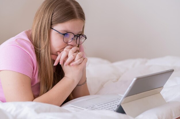 Focused teenager in glasses taking foreign languages courses via tablet