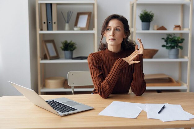 Focused thoughtful unhappy sad curly beautiful woman lost in\
heavy thoughts looks aside think about difficult life decision\
sitting at home office people problems concept