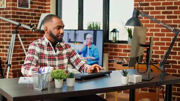 Foto dipendente stanco e concentrato che lavora da remoto, rispondendo alle e-mail di lavoro stressate dalle scadenze. telelavoratore oberato di lavoro che digita attentamente i dati sul computer in un caldo e accogliente appartamento soggiorno