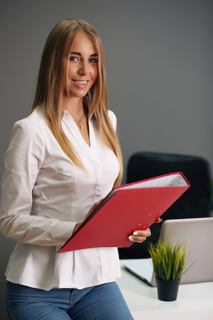 Focused woman holding red folder