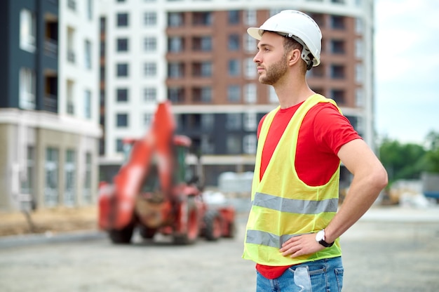 Photo focused worker in a hardhat looking into the distance