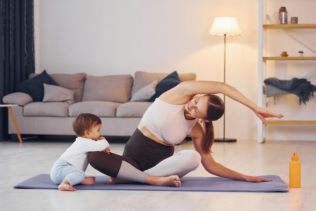 Incentrato sugli esercizi di yoga la madre con la sua piccola figlia è a casa insieme