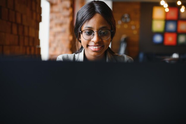 Focused young african american businesswoman or student looking
at laptop, serious black woman working or studying with computer
doing research or preparing for exam online