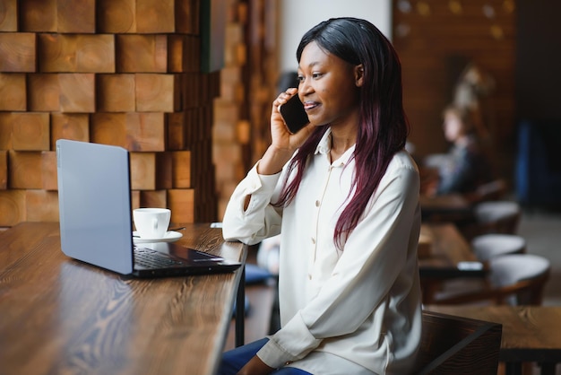 Focused young african american businesswoman or student looking at laptop serious black woman working or studying with computer doing research or preparing for exam online