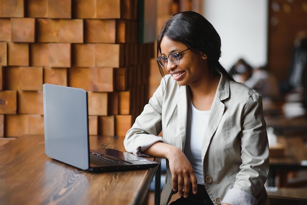 Focused young african american businesswoman or student looking at laptop serious black woman working or studying with computer doing research or preparing for exam online