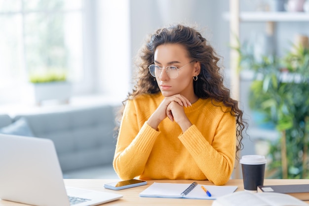 Focused young businesswoman studying online watching webinar podcast on laptop