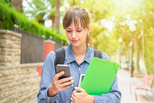 Focused young female student checking her phone