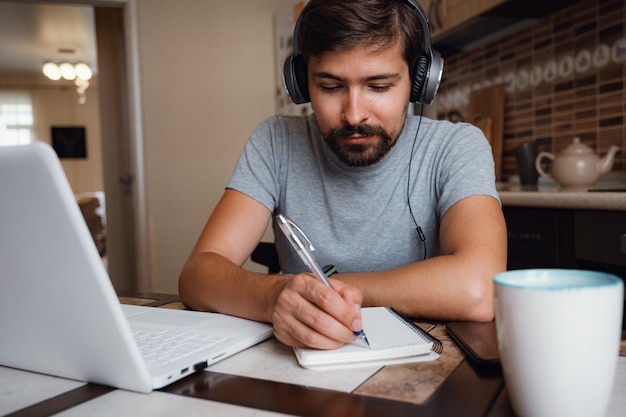 focused young man wear headphones study online