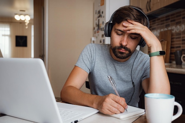 Focused young man wear headphones study online