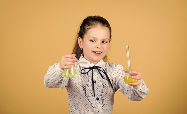 Focussen op werk kind studie biologie les wetenschappelijk onderzoek in laboratorium Klein schoolmeisje terug naar school klein slim meisje met testfles onderwijs en kennis Geïnspireerd om hard te werken