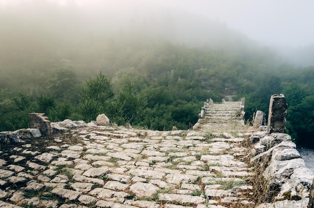 Fog and the ancient stone bridge of Plakidas