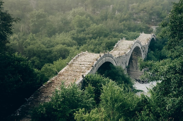 Photo fog and the ancient stone bridge of plakidas