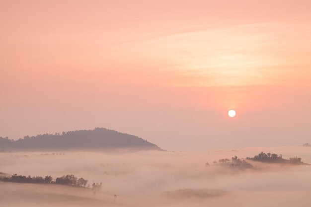 Photo fog covered mountains and the rising sun