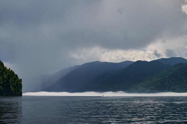 Туман в горной долине. Утренний туман над озером в горах Алтая.