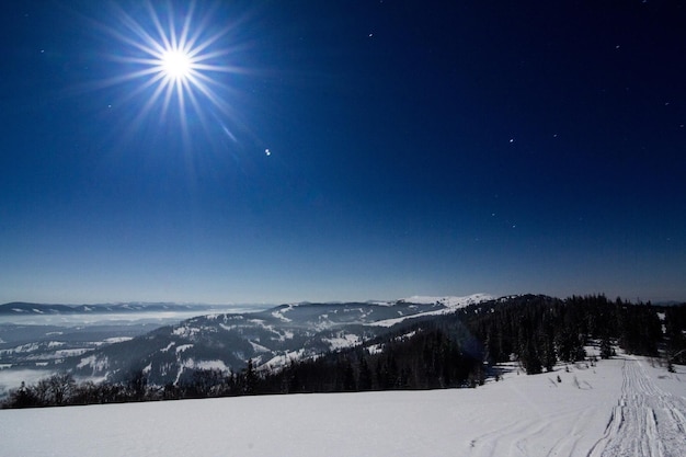 Fog moving over the mountain in winter with a starshaped sky