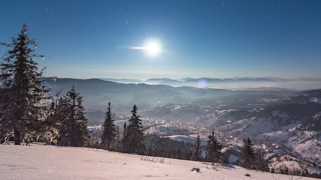 Fog moving over the mountain in winter with a starshaped\
sky