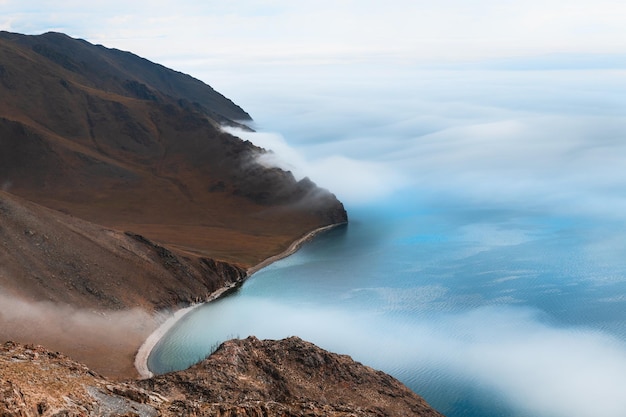 Fog over the shore of Baikal lake and mountains. Baikal lake, Siberia, Russia. Beautiful spring landscape