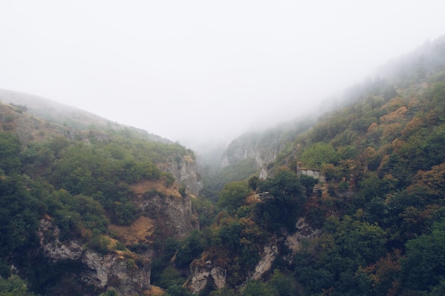 Fog view on the Khndzoresk ancient cave city in the mountain rocks Armenia landscape attraction Abandoned ruins in the mist Atmospheric stock photography