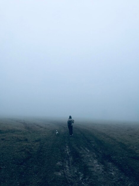 Photo fog woman dog empty field