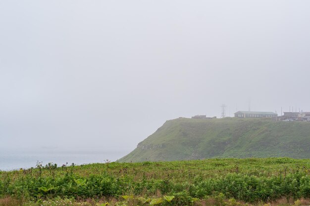 Foggy cape with a telecommunication point in a gloomy sea