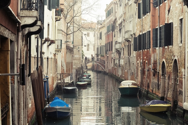 Foggy morning in Venice. View of narrow canal between old buildings