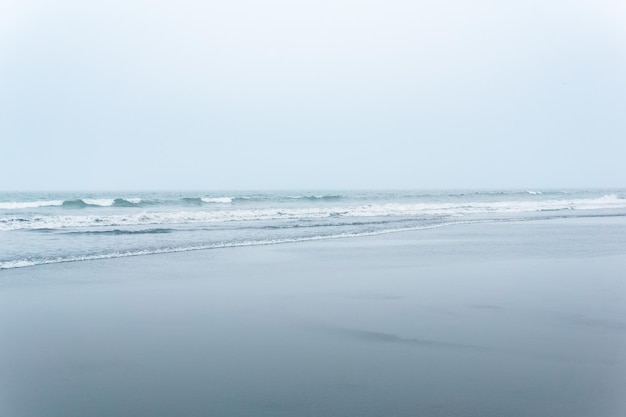 Берег океана туманного морского пейзажа холодный с широким пляжем