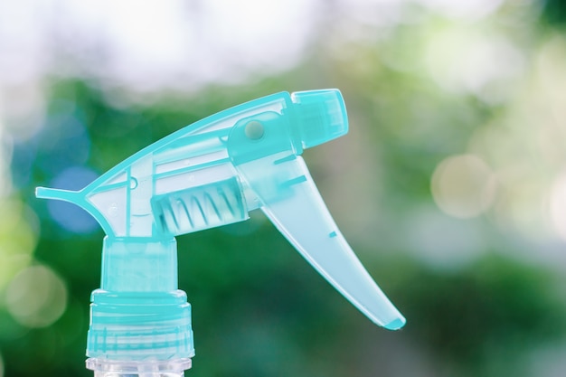 Foggy spray bottle against blurred natural green background