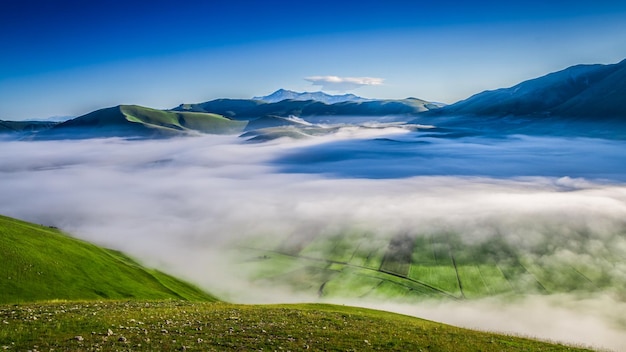 Туманный восход солнца в горах около Castelluccio Umbria Италия