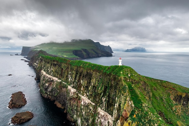 Foggy view of old lighthouse on the Mykines island