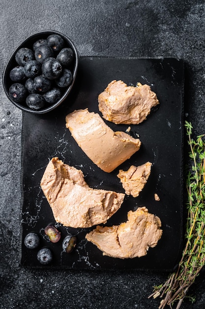 Foie gras duck liver pate and fresh blueberry Black background Top view