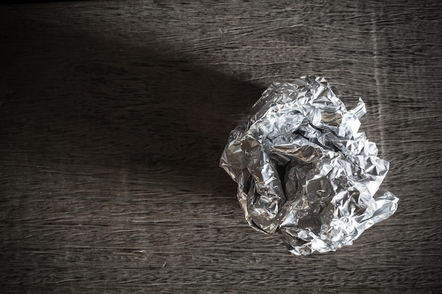 Foil ball on wooden background Picture dark tone