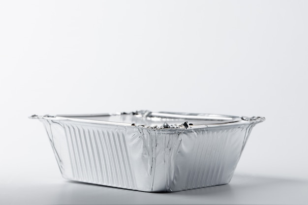 Foil food box with takeaway meal on white background