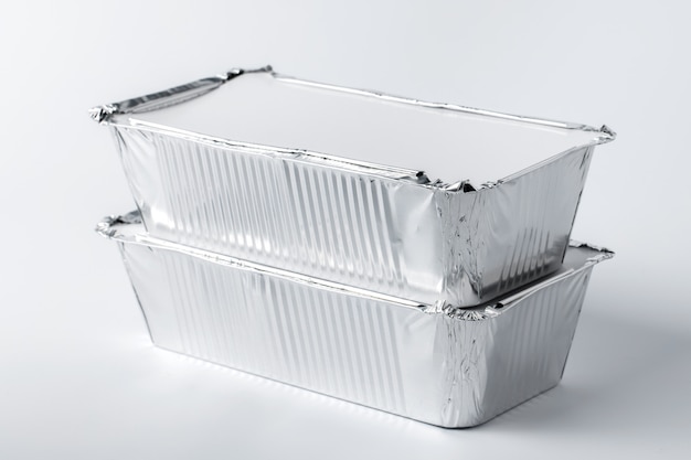 Foil food box with takeaway meal on white