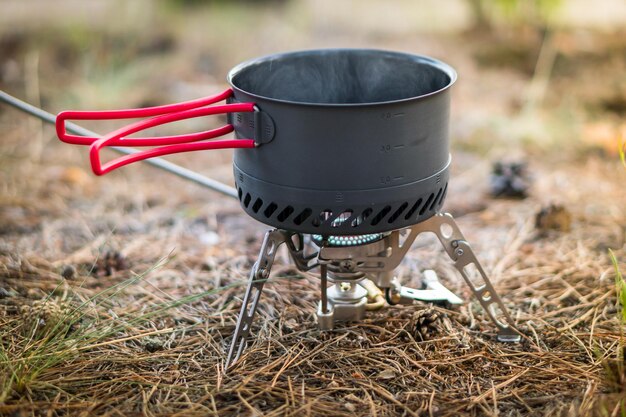 Sistema di fuoco a gas da campeggio pieghevole con pallone a gas e una pentola con radiatore per un riscaldamento rapido. concetto di stile di vita avventuroso