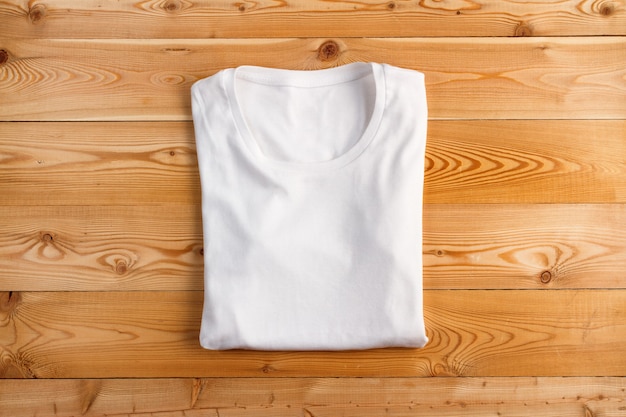 나무 배경에 접힌 여성 흰색 티셔츠
