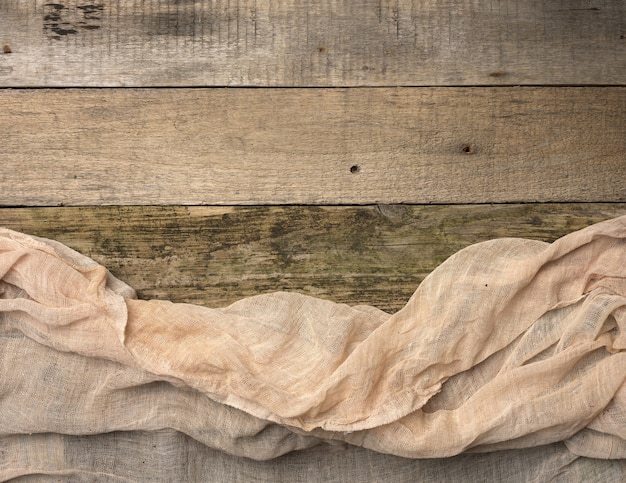 Folded gauze towel on a table made of old gray wooden boards, copy space