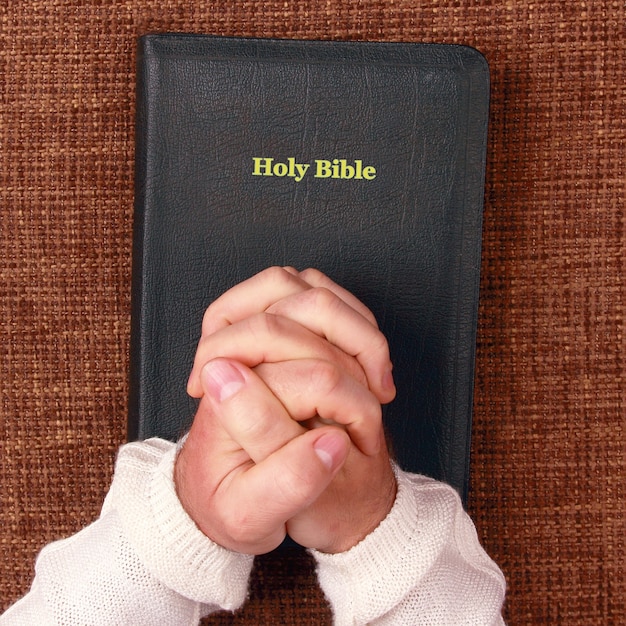 Foto mani giunte dell'uomo nella sacra bibbia