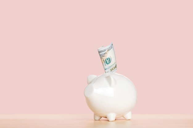 a folded one hundred dollar bill in a piggy bank saving money for the future