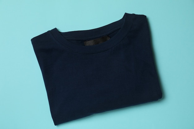 Photo folded t-shirt on blue, top view