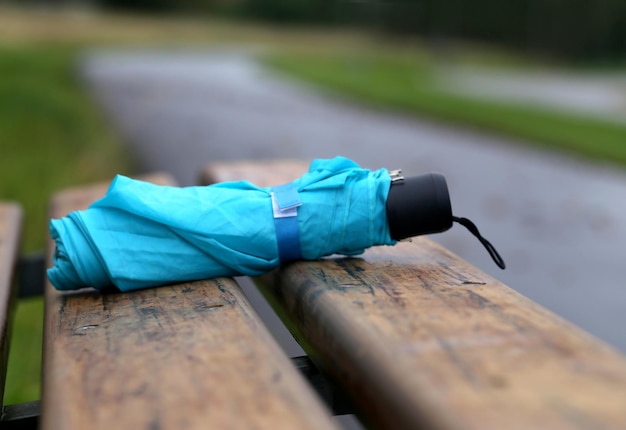 Folded umbrella on a bench outdoor