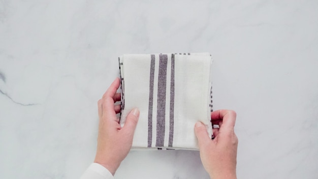 Folding Blck and white patterned paper towels on marble surface.