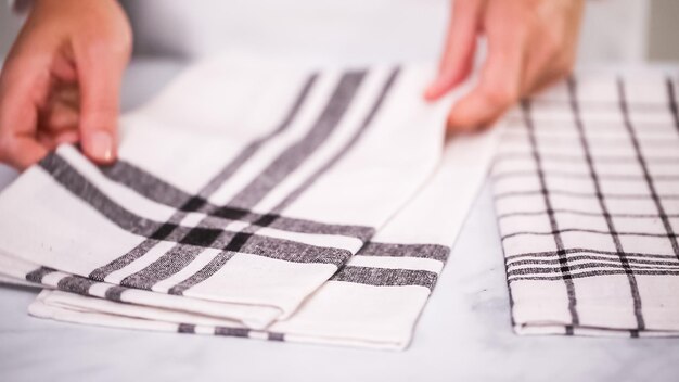 Folding Blck and white patterned paper towels on marble surface.