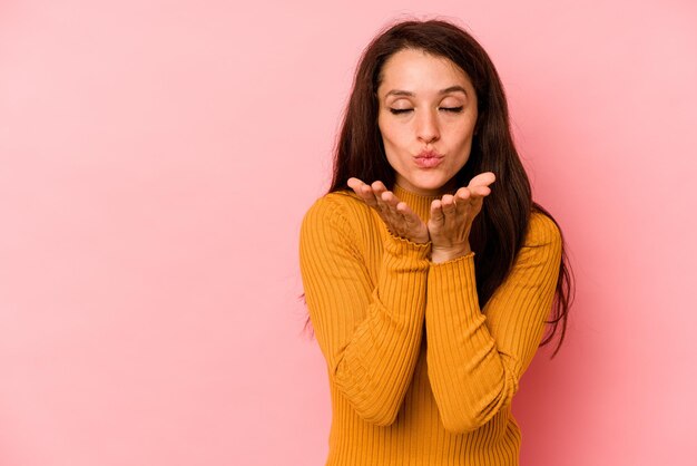 Foto piegare le labbra e tenere i palmi delle mani per inviare un bacio d'aria