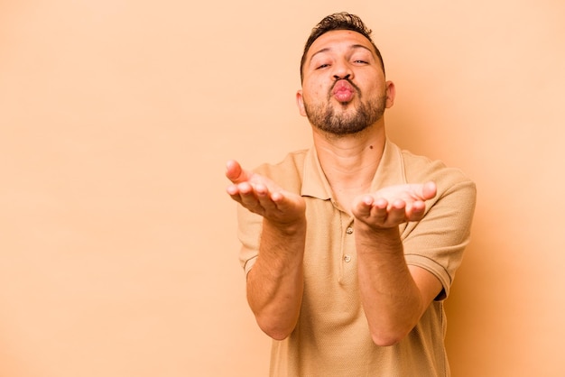 Foto piegare le labbra e tenere i palmi delle mani per inviare un bacio d'aria