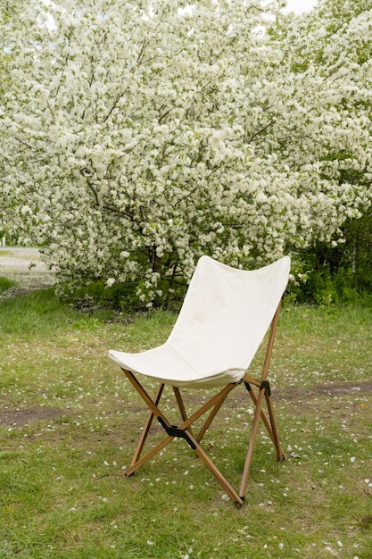 Folding wooden chair in a blooming park