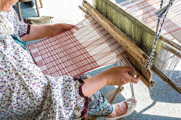 Folk Art Festival A woman weaver makes fabric on a hand loom