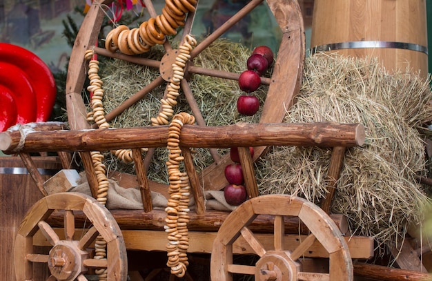 Foto decorazioni popolari per la festa di maslenitsa carro di legno con fieno e bagel mele rosse