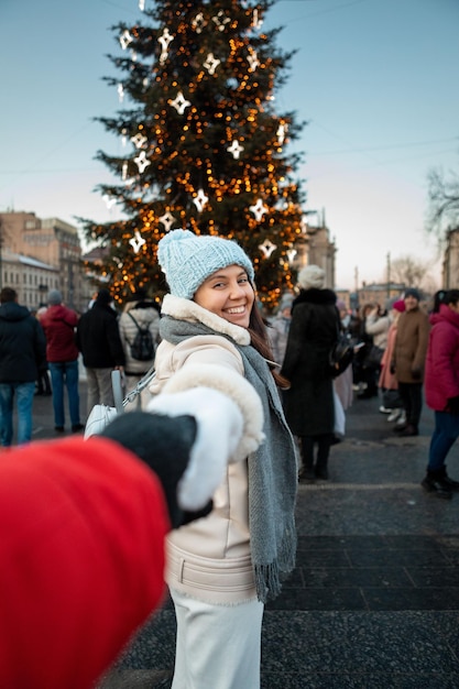 Следуй за мной, концептуальная женщина тянет мужчину к рождественской елке